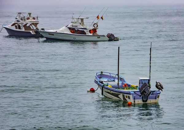Puerto Lopez, Ecuador - September 12, 2018 - One small tender boat comes in to the beach from a fishing boat. — Stock Photo, Image