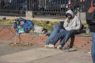 Duvar bir parkta Boston, Massachusetts - 25 Ekim 2018 - evsiz bir adam bir tuğla üzerinde uyuyor.