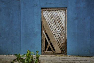 La Entrade, mavi duvar Ekvador - 14 Eylül 2018 - yıpranmış boyanmamış kapıda.