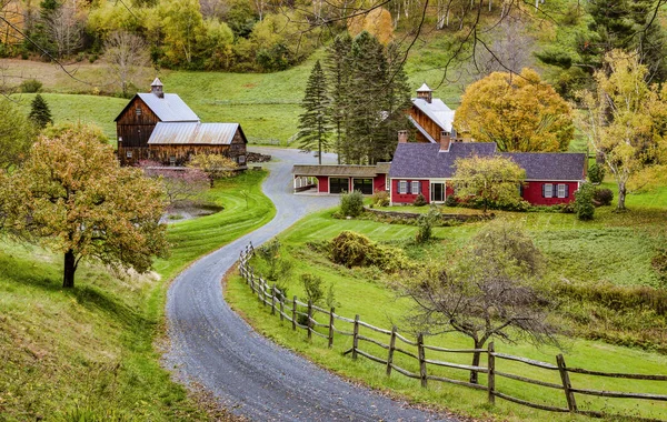 Woodstock, Vermont - 8 de outubro de 2018 - Uma estrada atravessa fazendas e árvores coloridas durante o outono . — Fotografia de Stock