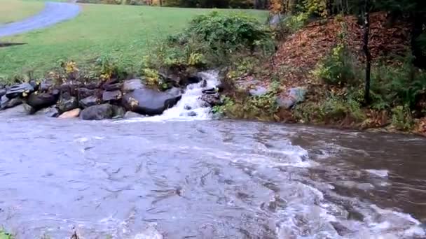 Corriente lateral entra en el río en pequeña cascada de agua en Vermont — Vídeos de Stock