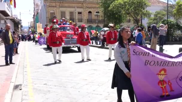 Cuenca, ecuador - 1. dezember 2018 - feuerwehrleute schließen sich den pfadfindern bei der parade an. — Stockvideo