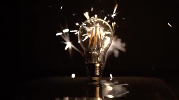 Sparkler Behind LED Light Bulb With Out of Focus Sparks. — Stock Video