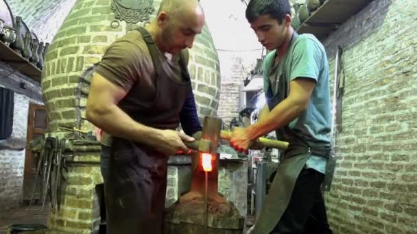 Bujará, Uzbekistán - 20170522 - Dos herreros doblan el metal caliente . — Vídeos de Stock