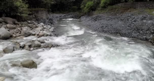 Banos, Ecuador-20180925-Drone säkerhetskopierar vit vattnet i floden på låg höjd. — Stockvideo