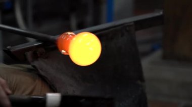 Glassworking sanatçı rulo kırmızı-sıcak top cam 4 k üfleme için hazırlık.