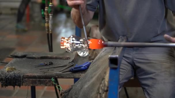 Travailleur du verre roule le verre chaud tout en travaillant avec l'outil de coupe 4K . — Video