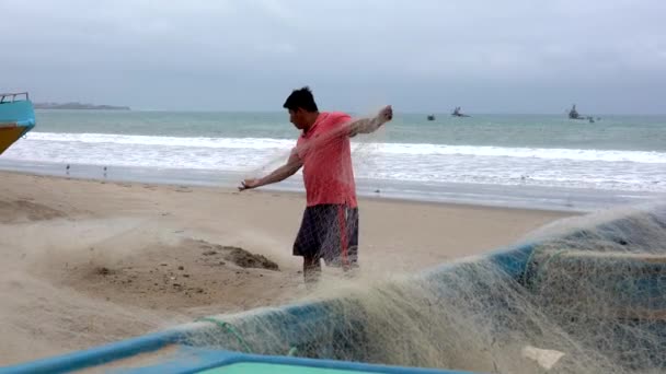 San Pedro, Ecuador - 20180915 - El hombre se para en la playa junto a la red de barcos y reparaciones . — Vídeo de stock