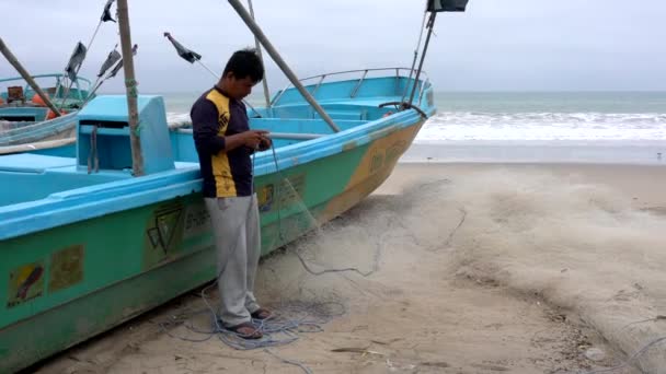 San Pedro, Ecuador - 20180915 - Man Stands by Boat and Repairs Net. — Stock Footage San Pedro, Ecuador - 20180915 - Man Stands by Boat and Repairs Net. Video Clip