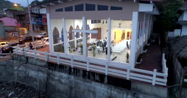 La entrada, ecuador - 20180914 - Drohne Antenne - Drohne schwenkt rechts - nach links im Abstand über gläserne Kirche mit Menschen im Inneren. — Stockvideo
