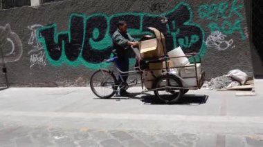Cuenca, Ekvador - 20180920 - adam o geri dönüşüm karton ile dolu üç tekerlekli bisiklet yürür..