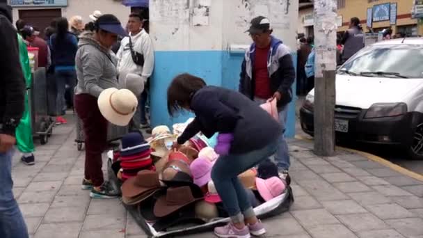 Latacunga, Εκουαδόρ - 20180923 - πλανόδιος πωλητής πωλεί καπέλα από μια κουβέρτα. — Αρχείο Βίντεο