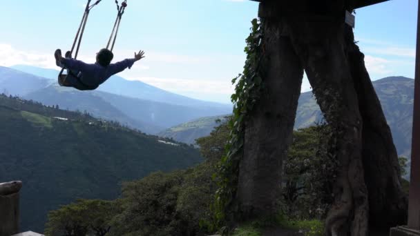 Banos, Ecuador - 20180924 - Woman Holds Arms Wide on Casa de Arbol Swing Over Abyss. — Stock Video