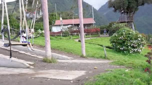 Banos, Ecuador - 20180924 - Девочка зажата отцом на качелях Casa de Arbol . — стоковое видео