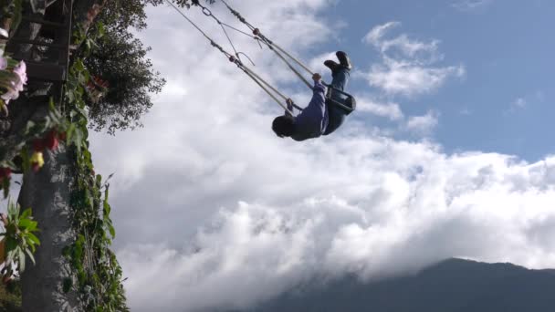 Banos, Ecuador - 20180924 - La donna ruota e getta braccia larghe su Casa de Arbol Swing Over Abyss Against Clouds . — Video Stock