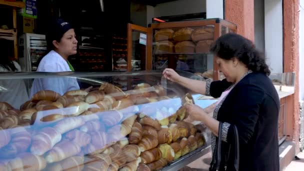 Cuenca, Ecuador - 20180920 - Mujer compra pan de Panaderia Bread Store frente a la calle . — Vídeo de stock