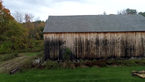 Antenowe Drone - Pan obok starej stodole kierunku żywe kolorowe drzewa jesienią w Vermont 4k. — Wideo stockowe