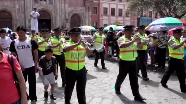 Cuenca, ecuador - 20160206 - Polizeikapelle marschiert in Parade gefolgt von Mann auf Stelzen. — Stockvideo