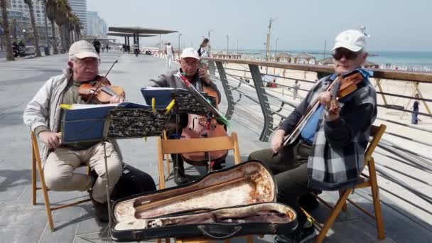 Tel Aviv, Izrael-2019-04-27-starší strunové muzikanti na pláži se zvukem 2-pohled dolů na Promenprocházku — Stock video