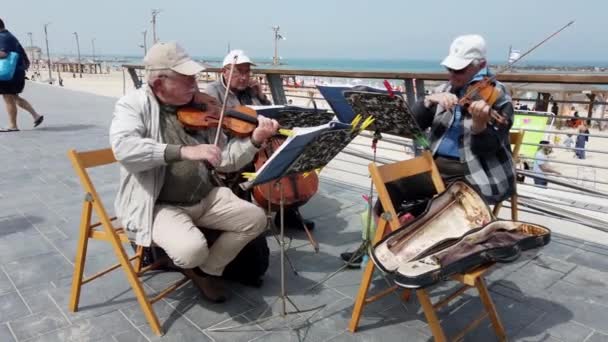 Tel Aviv, Israël-2019-04-27-oudere snaar muzikanten op het strand met Sound 3-met voorbijgangers — Stockvideo