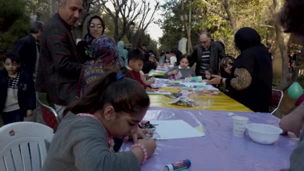 Tehran, iran - 2019-04-03 - street fair entertainment 11 - Kinder basteln Tisch 3 — Stockvideo