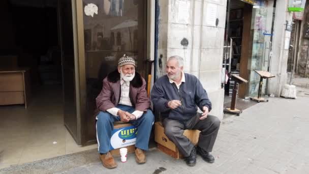 Amman, Jordanie - 2019-04-18 - Deux hommes âgés assis sur des boîtes et discutent — Video