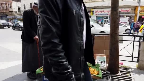 Amman, Yordania - 2019-04-18 - Street Vendor Sits on Crate And Makes a Sale of His Fruits — Stok Video