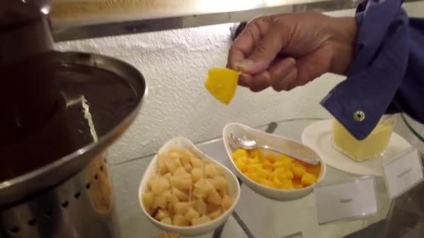 Шоколадний фонтан занурення манго шматок — стокове відео