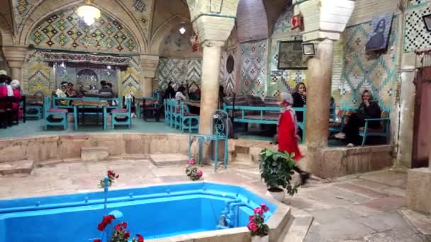 Kerman, iran - 06.04.2019 - Frau in Rot geht durch iranisches Restaurant — Stockvideo