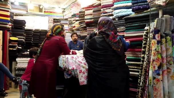 Kashan, Iran - 2019-04-15 - Two Women in Scarves Shop For Cloth — Stock Video
