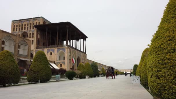 Isfahán, Irán - 2019-04-12 - Paseo en carruaje a caballo alrededor de la plaza Naqshe Cehan 3 - Tres pasajeros uno con teléfono — Vídeo de stock