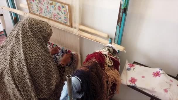 Isfahan, Iran - 2019-04-12 - Elderly Woman Weaves Carpet 2 - Over Shoulder — Stock Video