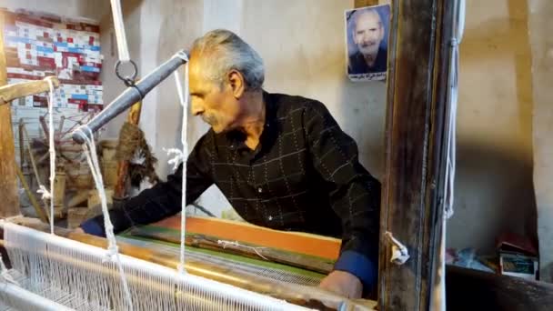Isfahan, Iran-2019-04-12-oudere man weeft Aliaqa mantel 1-front — Stockvideo