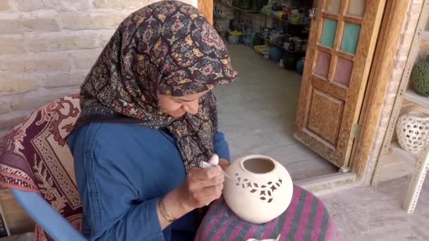 Isfahan, iran - 2019-04-12 - Frau graviert vor dem Brennen Keramik — Stockvideo