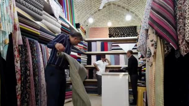 Шираз, Иран - 2019-04-08 - Cloth Merchant Rerolls Product — стоковое видео