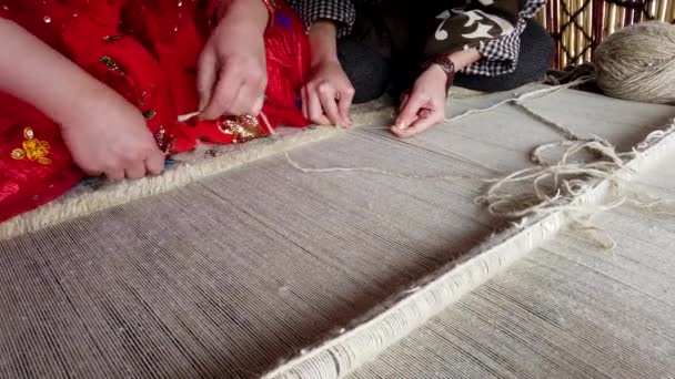 zwei qashqai frauen arbeiten zusammen, um teppich zu weben