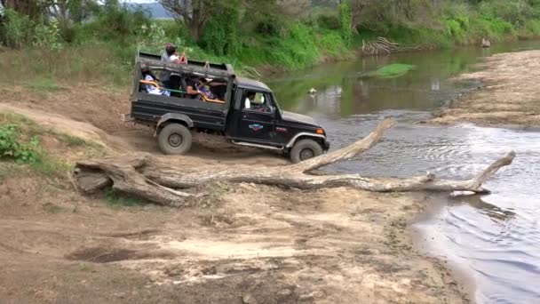 Parque Nacional de Minneriya, Sri Lanka - 2019-03-23 - Caminhão de jipe verde passa preso no rio — Vídeo de Stock