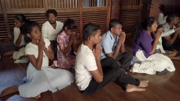 Kandy, Sri Lanka-09-03-24-ludzie módlcie się siedząc w sali w hołdzie dla Buddy — Wideo stockowe