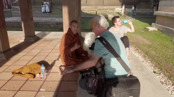 Kandy, Sri Lanka-09-03-24-fotograaf praat met monnik tegenover monnik — Stockvideo