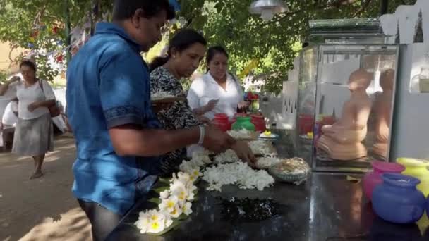 Kandy, sri lanka - 09-03-24 - Menschen legen Blumen zu Ehren des Buddha nieder — Stockvideo