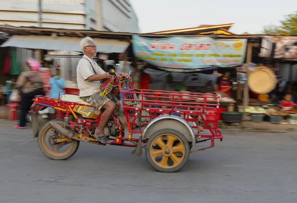 Sukhothai, Tahiland-2019-03-06-stary człowiek napędza jego trzy kołowe Motor koszyk przez rynek — Zdjęcie stockowe