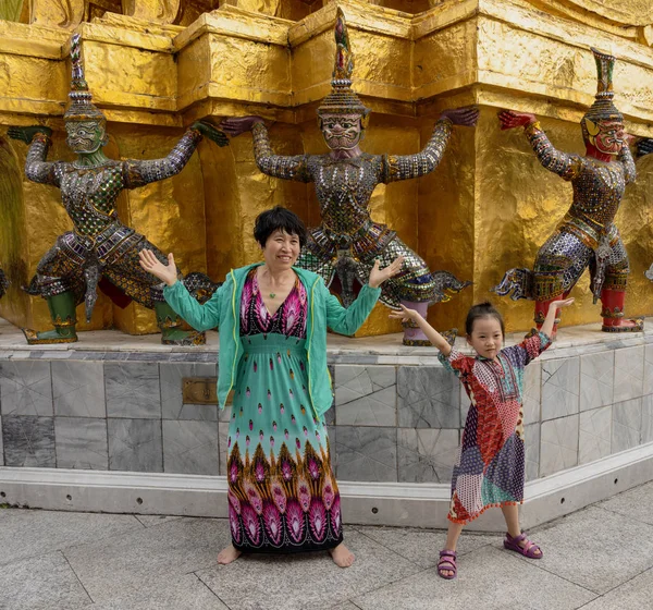Bangkok, Tahilandia - 2019-03-04 - La madre y el niño se ponen a juego con las estatuas hindúes del Gran Palacio —  Fotos de Stock