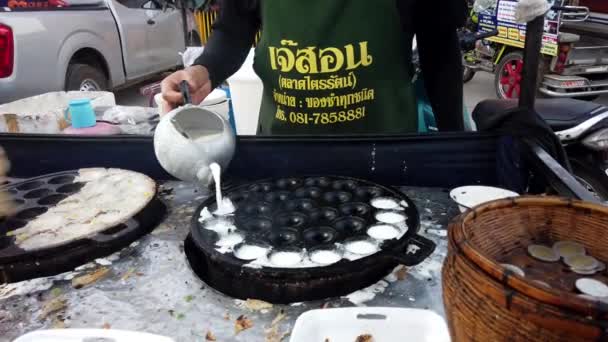 Сукхотай, Таиланд - 2019-03-06 - Man Pours Cream-Egg Mixture Into Iron Depression Pan For Making Treats — стоковое видео