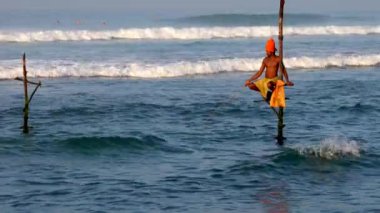 Galle, Sri Lanka-2019-04-01-stilt balıkçılar-turuncu türban ve yansıma içinde yalnız adam