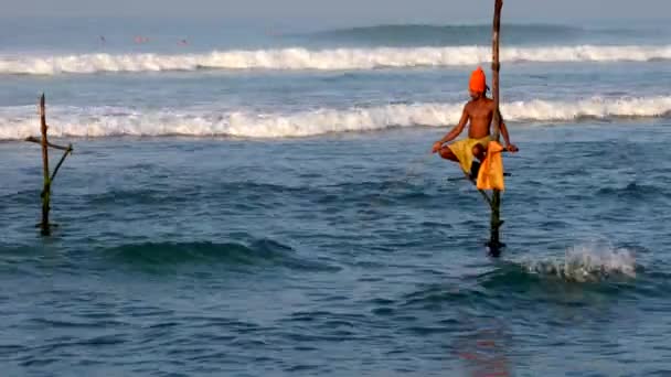 Galle, Srí Lanka-2019-04-01-Stilt-rybáři-samotář v oranžovém turbanu a reflexi — Stock video