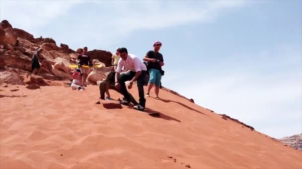 Wadi rum, jordan - 2019-04-23 - Mann versucht mit Snowboard Sanddüne hinunterzurutschen, kann aber nicht rutschen — Stockvideo