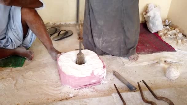 L'homme utilise un ancien outil pour sculpter le centre de ce qui deviendra un vase en pierre — Video
