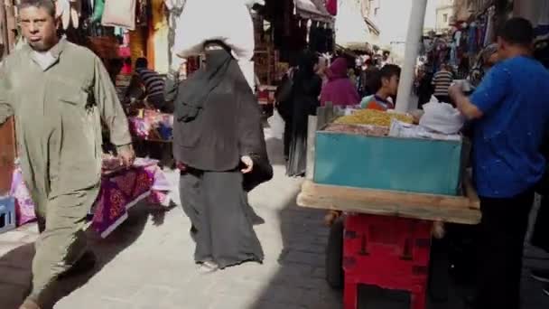 Kairo, Ägypten - 2019-05-03 - belebte Bizaare Straße mit Frau im Hijab, die Paket auf dem Kopf trägt — Stockvideo