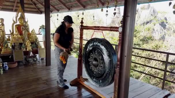 Phayao, Tajlandia-2019-03-08-z dźwiękiem-Tourist bangs Buddyjski Gong 2 — Wideo stockowe