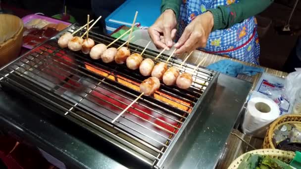 Phayao, Thailand-2019-03-08-mat säljaren roterar kyckling korv på spisen — Stockvideo